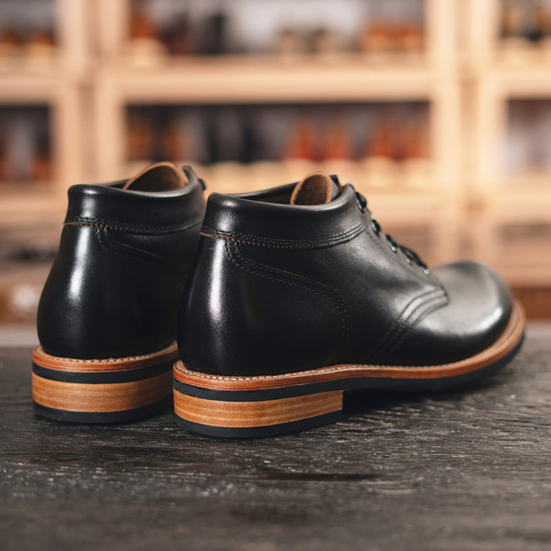 A sleek black leather boot featuring a durable rubber sole, ideal for both style and comfort in various settings.