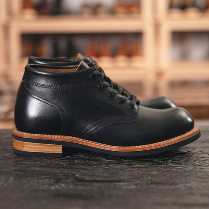 A sleek black leather boot featuring a durable rubber sole, ideal for both style and comfort in various settings.